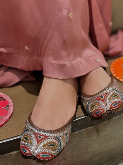 For those who love color, these juttis feature beautiful multi-colored threadwork in a geometric pattern, making them a standout accessory.