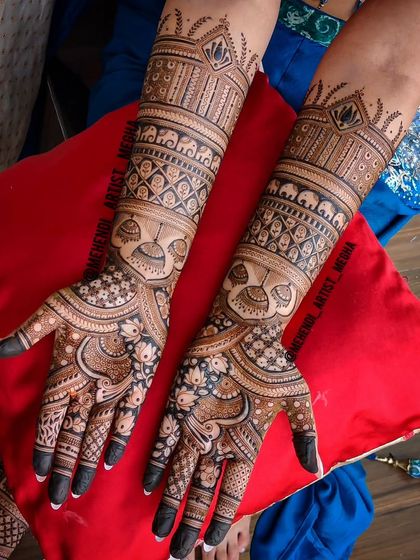 This bridal design features beautiful kalash (ceremonial pot) motifs on the arms, symbolizing prosperity and new beginnings. The palms are adorned with intricate floral and checkerboard patterns.