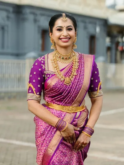 A radiant bride in a vibrant purple Kanchipuram silk saree. I designed the matching blouse with traditional motifs and detailed embroidery along the neckline and sleeves to perfectly complement the rich texture of the silk.