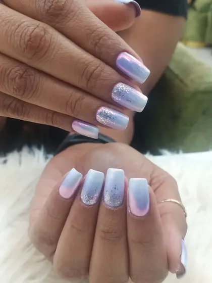 This dreamy manicure features a soft, iridescent chrome finish that shifts between pastel blue and lavender. Silver glitter accents on the ring fingers add an extra touch of magic.