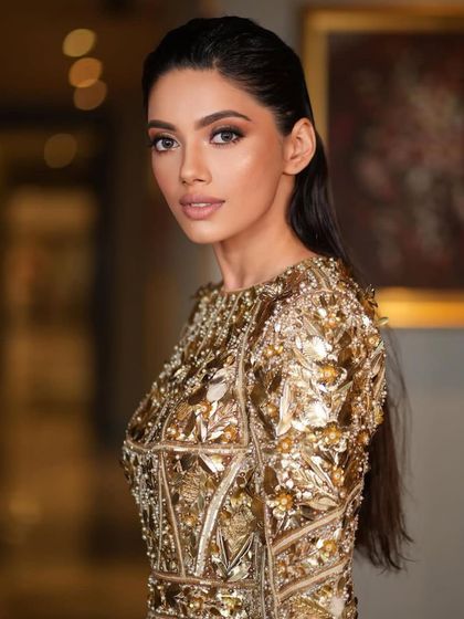 Another close-up of the gold mini dress look, focusing on the soft, glowing makeup and the confident expression.