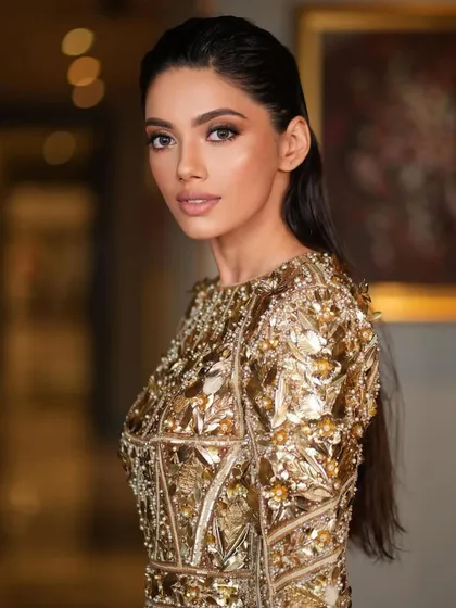 Another close-up of the gold mini dress look, focusing on the soft, glowing makeup and the confident expression.