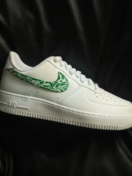 A clean white Nike Air Force 1 with a green paisley pattern filling the swoosh.