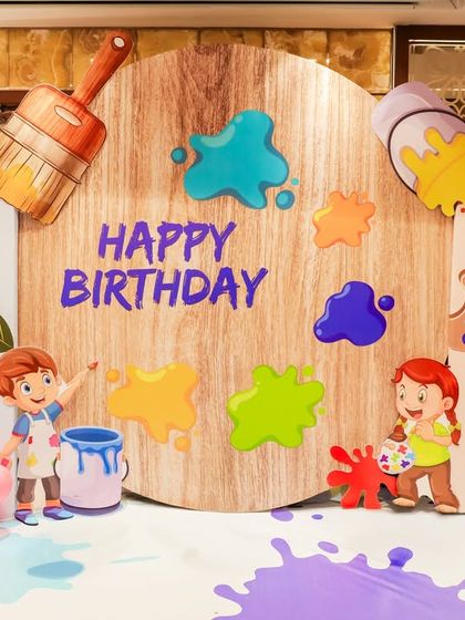 A close-up of the personalized birthday backdrop for an Art theme party. Featuring cute illustrations, 3D paint splatters, and a rustic wooden finish, it's the perfect spot for birthday photos.