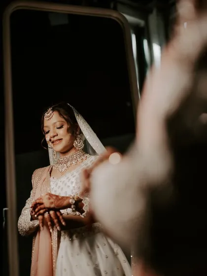 A candid moment of the bride admiring her final look in the mirror. Her soft smile reflects her confidence and comfort, which is always my ultimate goal.