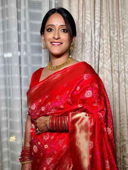 The rich red of her saree and the warmth of the gold jewelry are perfectly complemented by a flawless, glowing complexion. This is a look rooted in tradition and grace.