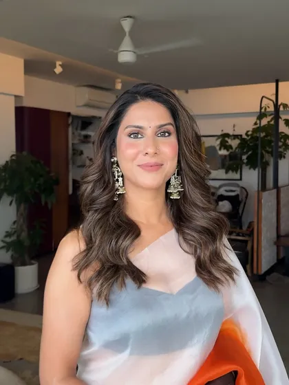 A beautiful portrait of a client with her hair styled in dramatic, face-framing waves, perfect for any special occasion.