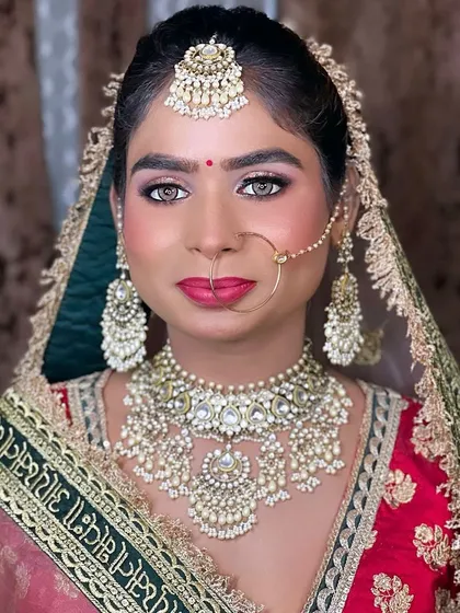 A beautiful bridal portrait of my hairstylist Nisha, showcasing a flawless look on her dusky skin tone. The pink and green outfit is complemented by soft glam makeup.