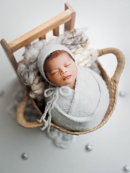 Wrapped in comfort and loving this soft grey color palette. The cozy bonnet and swaddle keep the baby warm and sleepy in this basket setup.