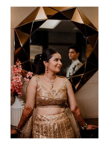 An artistic portrait using a mirror to reflect the groom while the bride is in the foreground. This creative composition adds a layer of intrigue and romance to the image.