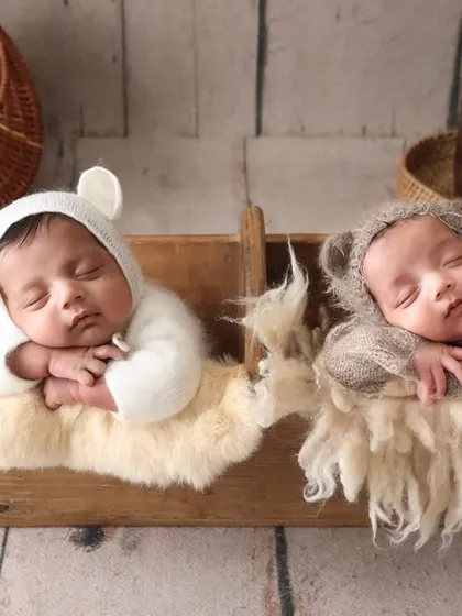 Two little bears, sleeping side by side. Capturing newborn twins requires special care and patience. This setup with bear bonnets highlights their individual smallness and their beautiful bond.