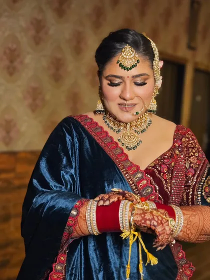 A stunning plus-size bride looking absolutely radiant. We used a deep blue velvet dupatta to complement her maroon lehenga, with makeup that highlighted her beautiful features.