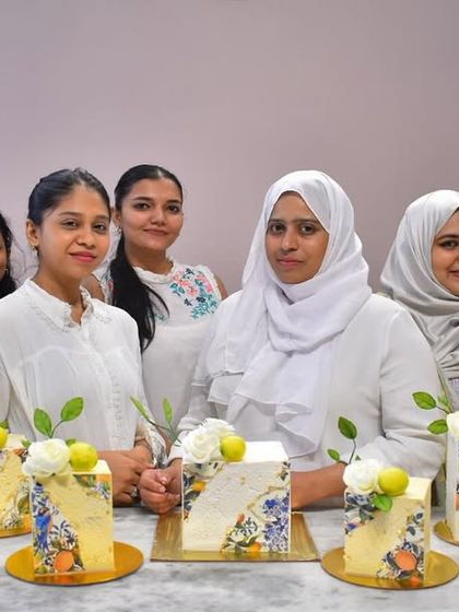 My talented students showcasing their premium square cakes, each decorated with a unique floral and fruit stencil design.
