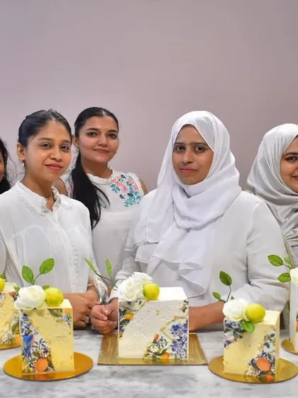 My talented students showcasing their premium square cakes, each decorated with a unique floral and fruit stencil design.
