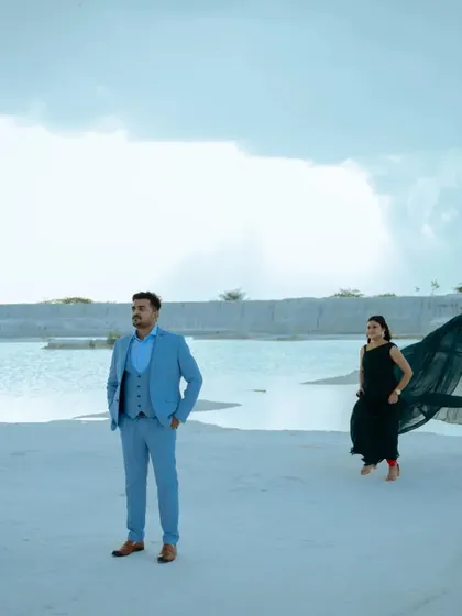 This creative shot captures the groom in the foreground with the bride and her flowing gown creating a dramatic shape in the background. It’s a great example of artistic pre-wedding photography.