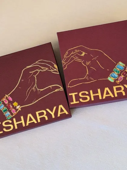 A pair of boxes with a heart-hands design, customized for the Isharya event.