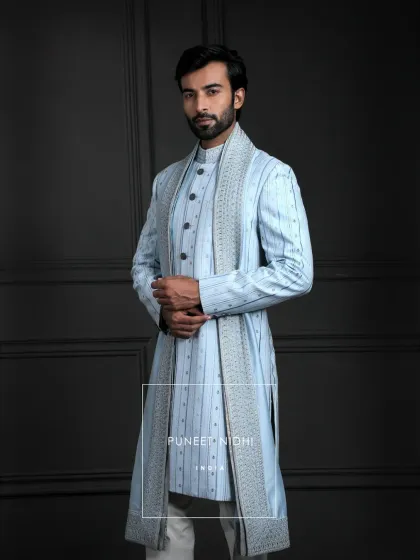 A canvas of ice blue woven with artistry. Pintucked lines, delicate thread embroidery, and shimmering sequins are paired with white trousers and a graceful stole for a celebration of magnificence.