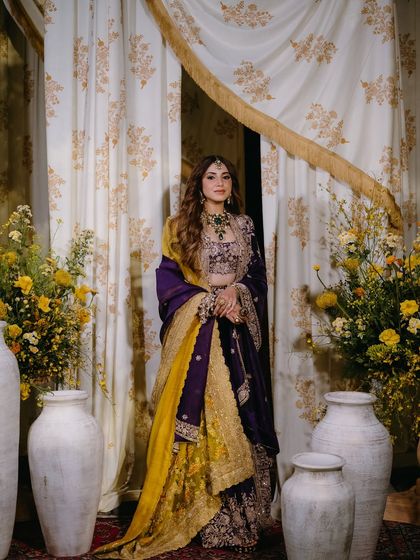 The bride, looking regal in her purple and yellow ensemble, perfectly framed by the decor of her Kashmiri Sufi themed Mehfil.