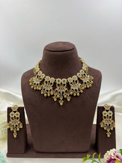 The Jasira premium antique gold necklace set. This piece is perfect for festive occasions, featuring detailed motifs and ghungroo-style bead droppings for a classic sound and feel.