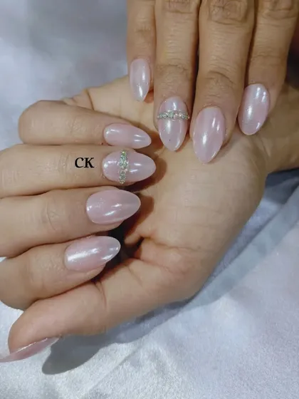 A beautiful set of white chrome nails. The pearlescent finish is simple and elegant, with a delicate band of rhinestones for a touch of sparkle.