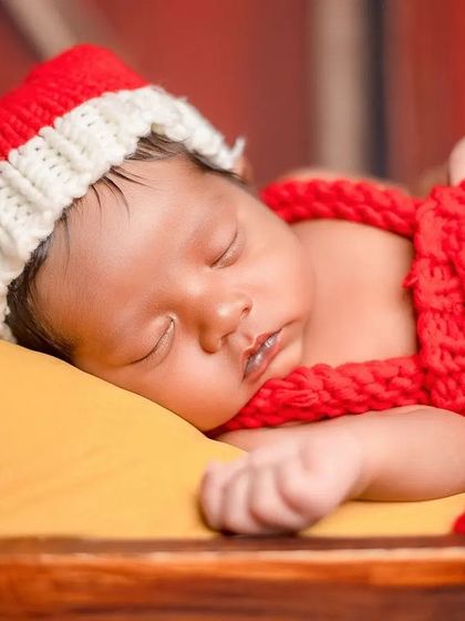 A peaceful moment captured during the Christmas-themed newborn session. The focus is entirely on the sleeping baby.