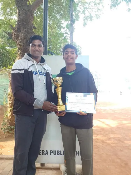 Divyansh Lekhi receives his winner's trophy for the All India AITA U-14 tournament. This photo captures the moment of victory on a sunny day at the court.