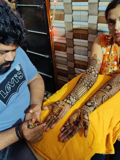 Here I am, at work with a happy client. You can see the finished, intricate design on both her arms. I ensure every client is comfortable and leaves with a design they absolutely love.