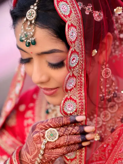 A detailed bridal portrait is essential. This close-up focuses on the intricate details of the bride's makeup, jewelry, and the delicate embroidery of her veil, showcasing her elegance and the quiet moments of anticipation.