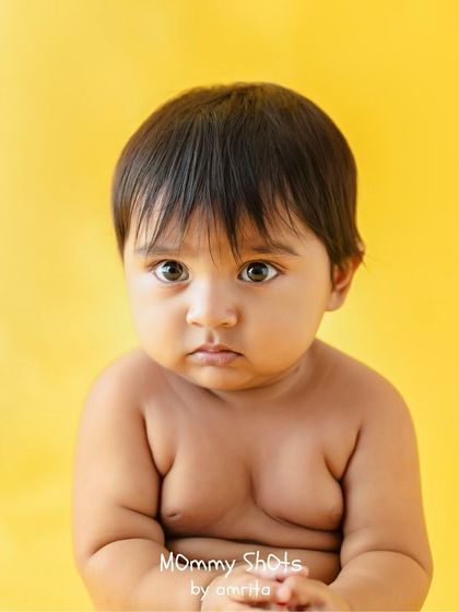 A cute baby portrait with a bright yellow background, showing mastery of color and simple composition.