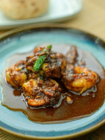 A close-up of the 'Not so Balchao' from The Second House, Goa. This dish features fresh local prawns in a rich, flavorful red chili and kaffir lime sauce.