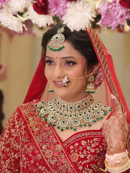 Urvashi's subtle and natural bridal look. We focused on soft, shimmery eyes and flawless skin to complement her gorgeous red lehenga and emerald jewellery.