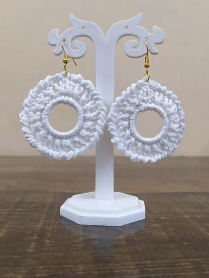 The white hoop earrings displayed on a stand. These handmade earrings are great for gift hampers or bridal party favors.
