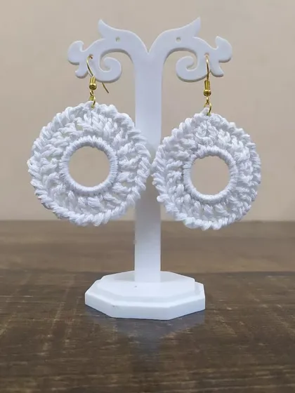 The white hoop earrings displayed on a stand. These handmade earrings are great for gift hampers or bridal party favors.