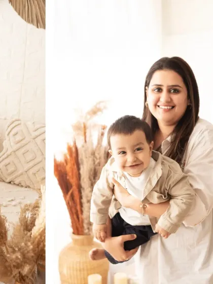 A mother holds her smiling baby boy. These simple, heartfelt portraits are often the most cherished.
