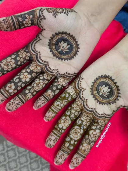 A beautiful mandala design with a lotus inside. The fingers are adorned with a delicate floral pattern, creating a very feminine and graceful look.
