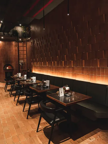 The warm and inviting interior of our Forum Kanakapura Road outlet, featuring our signature brick walls, terracotta tiles, and a glowing wood-fired oven.