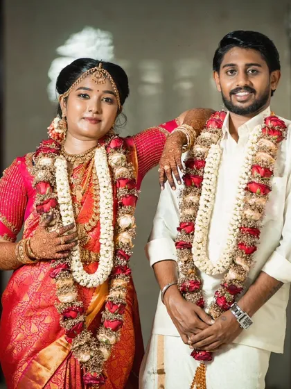 A happy couple portrait. The bride's red saree and traditional jewelry look stunning, and her makeup is perfectly balanced.