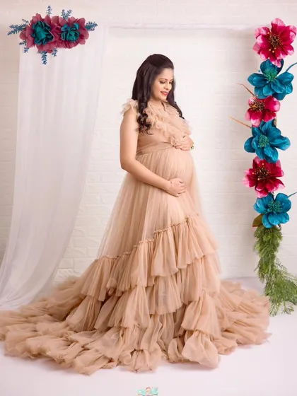 A beautiful solo shot showing the incredible texture and volume of this tiered tulle gown. It’s a perfect choice for a dreamy, high-fashion maternity look.
