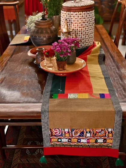 The autumnal runner styled on a dining table with earthy pottery, showing how it can set the mood for a seasonal tablescape.