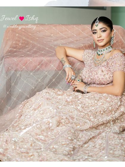 The full picture of bridal perfection. This look, combining a soft pink lehenga with the striking green of emeralds, is a testament to modern bridal glamour.