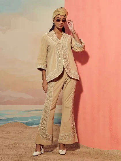 A full-body shot of a coordinated set from Qala Clothing, styled with a turban for a chic, resort-ready look.