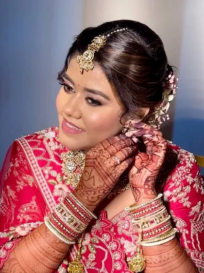 Final touches. This close-up shows the flawless base and defined eyes that make this red bridal look so striking.