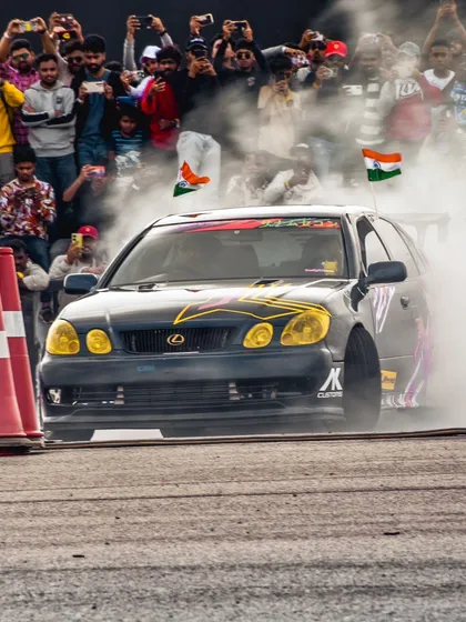 A custom Lexus drift car, surrounded by smoke and a roaring crowd holding Indian flags. This captures the patriotic pride and passion of the Indian motorsport community.