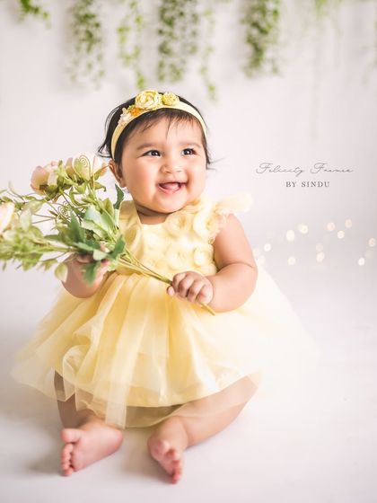 A little ray of sunshine holding a bouquet of flowers. This sitter session portrait is full of warmth, joy, and the simple beauty of childhood.