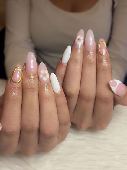 A full view of the elegant white, pink, and gold manicure.