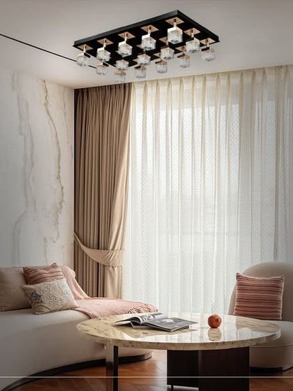 This living room features a modern rectangular ceiling fixture with multiple glass elements. It offers a contemporary alternative to a traditional chandelier, providing broad, even light with a sophisticated design.