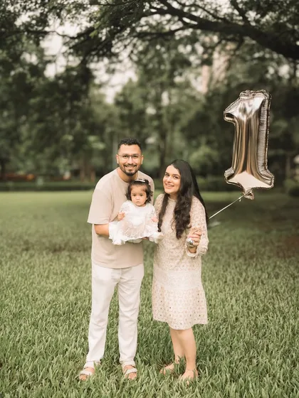 The whole family together, celebrating a very special first birthday with a golden balloon.