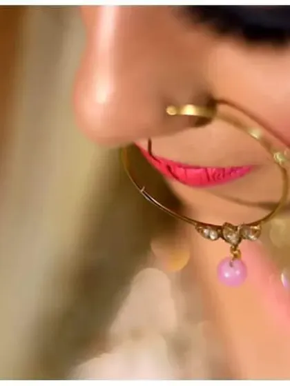 An artistic close-up of the bride's nath (nose ring), a classic detail in Indian bridal photography that adds a touch of elegance.