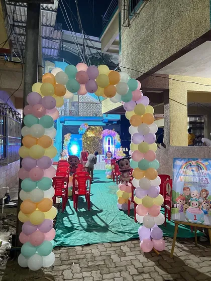 The entrance to a Cocomelon birthday party, featuring a pastel-colored balloon arch and a welcome sign with themed characters.