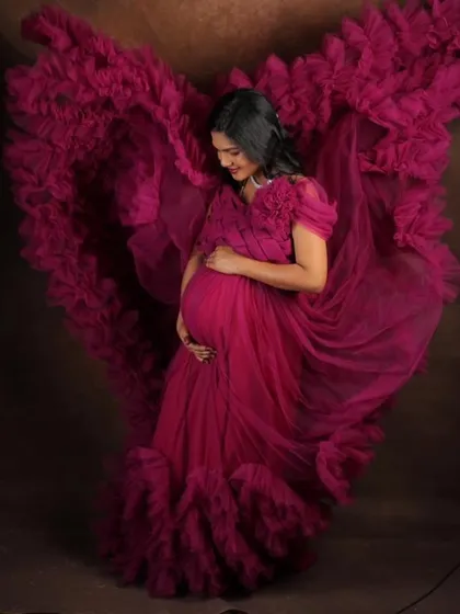Feel like a goddess in this magenta flying gown, designed to make your maternity photoshoot absolutely breathtaking. The way the ruffled trail catches the air creates stunning, dynamic images that you will cherish forever.